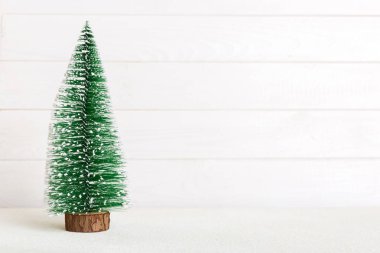 One small Christmas tree on colored background. new year decoration with copy space.