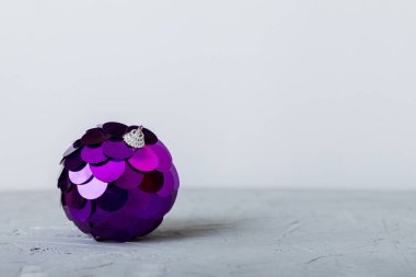Christmas ball on colored background. decoration bauble with ribbon bow with copy space.