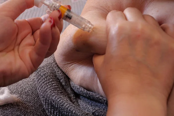 Woman is injecting hormones to belly with syringe. IVF concept close up.