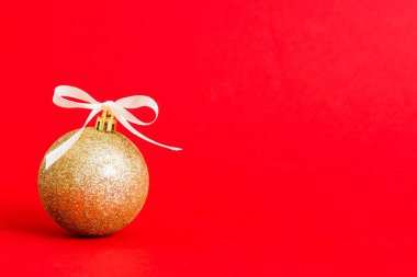 Christmas ball on colored background. decoration bauble with ribbon bow with copy space.