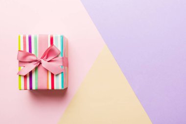 holiday paper present tied pink ribbon bow top view with copy space. Flat lay holiday background. Birthday or christmas present. Christmas gift box concept with copy space.