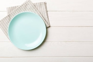 Renkli arkaplanda üst görünüm yiyecek için mavi tabak üzerinde boş. Tasarımınız için boşluk olan peçeteye boş tabak.