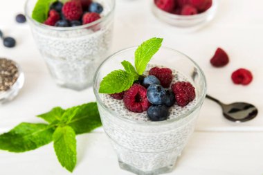 Sağlıklı kahvaltı ya da sabah chia tohumlu vanilyalı puding ahududu ve böğürtlen, vejetaryen gıda, diyet ve sağlık konsepti. Ahududu ve yabanmersinli Chia pudingi..