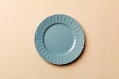 Renkli arka planın üst görüntüsü yiyecek için boş mavi tabak. Tasarımınız için alanı olan boş tabak.