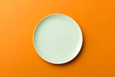 Renkli arka planın üst görüntüsü yiyecek için boş yuvarlak yeşil tabak. Tasarımınız için alanı olan boş tabak.