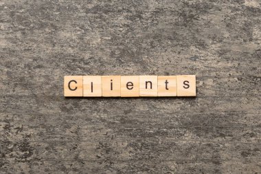 Müşteri sözcüğü ahşap blokta yazılı. Müşteriler masa üzerinde metin, konsept.