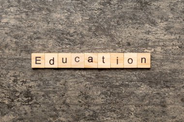 Tahta bloğa yazılmış eğitim kelimesi. Eðitim metni desing, konsept için çimento tablo üzerinde.