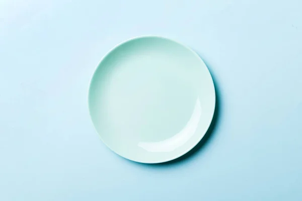 食品のための色の背景の空のラウンドブループレートの分離のトップビュー あなたのデザインのためのスペースと空の料理 — ストック写真