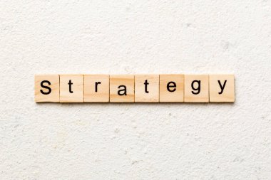 Tahta blokta STRATEGY kelimesi yazıyor. Beton masadaki STRATEGY metin desing, konsept için.