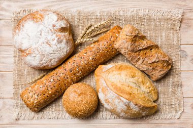 Kırsal masa manzaralı peçeteli taze pişmiş ekmek çeşitleri. Sağlıklı mayasız ekmek. Fransız ekmeği.