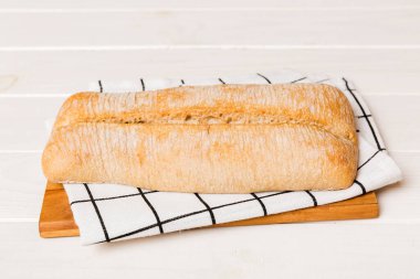 Tahtanın üzerinde beyaz ahşap zemine karşı taze pişmiş ekmek. Ekmeği kopyalama alanı ile perspektif görünümü.