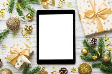 Digital tablet mock up with rustic Christmas decorations for app presentation top view with empty space for you design. Christmas online shopping concept. Tablet with copy space on colored background.