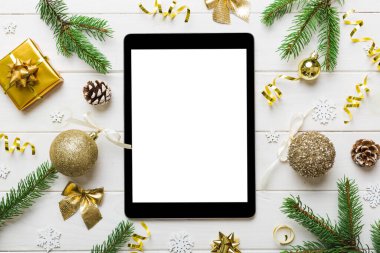Digital tablet mock up with rustic Christmas decorations for app presentation top view with empty space for you design. Christmas online shopping concept. Tablet with copy space on colored background.