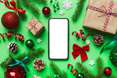 Digital phone mock up with rustic Christmas decorations for app presentation top view with empty space for you design. Christmas online shopping concept. Tablet with copy space on colored background.