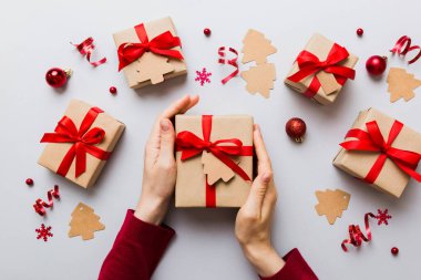 Kadın eli hediye kutusunu tutuyor, sürprizi hazırlıyor, üst manzara, Noel ve yeni yıl konsepti.