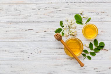 Akasya çiçekli ve yapraklı bal kavanozu. Taze bal üst görünüm düz yatıyordu.