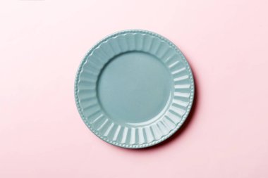 Renkli arka planın üst görüntüsü yiyecek için boş mavi tabak. Tasarımınız için alanı olan boş tabak.