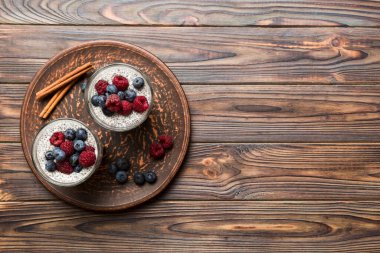 Sağlıklı kahvaltı ya da sabah chia tohumlu vanilyalı puding ahududu ve böğürtlen, vejetaryen gıda, diyet ve sağlık konsepti. Ahududu ve yabanmersinli Chia pudingi..