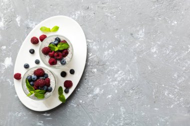 Sağlıklı kahvaltı ya da sabah chia tohumlu vanilyalı puding ahududu ve böğürtlen, vejetaryen gıda, diyet ve sağlık konsepti. Ahududu ve yabanmersinli Chia pudingi..