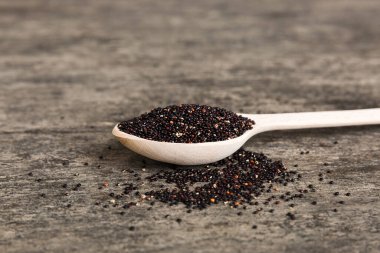 Renkli arka planda kaşık içinde kinoa tohumları. Küçük kaşıkta sağlıklı kinwa. Sağlıklı süper yiyecekler.