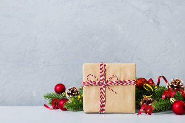 New Year Christmas mood, gift box, branches of a christmas tree, New Year decorations on a colored background.