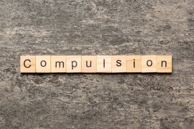 Tahta blokta yazan zorlama kelimesi. Masada baskı metni, konsept.