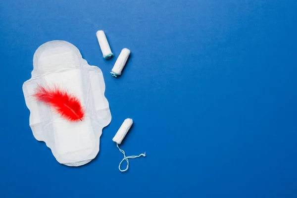 women pads and tampon - sanitary pads lies next to a tampon on an isolated background on a pink and violet background. Women's hygiene and menstrual period concept.