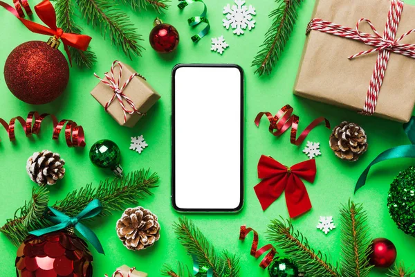 Digital phone mock up with rustic Christmas decorations for app presentation top view with empty space for you design. Christmas online shopping concept. Tablet with copy space on colored background.