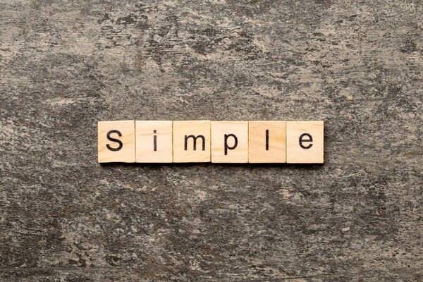 simple word written on wood block. simple text on table, concept.