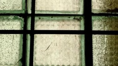 Eski bir sanayi binasının camındaki metal parmaklıklar. Terk edilmiş bir binanın kirli penceresi.
