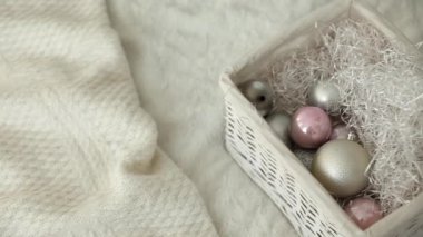 İçinde yeni yıl oyuncakları, topları ve süslemeleri olan beyaz hasır sepet. Yeni yıla ve Noel 'e hazırlanıyorum. Yılbaşı arkaplanı ve yeni yıl süslemeleri. Yukarıdan bak. Noel bekleme konsepti.