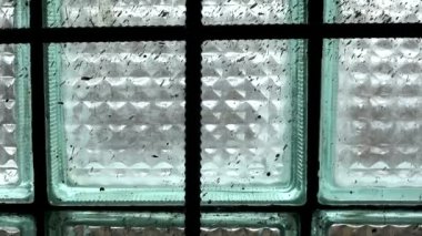 Terk edilmiş bir binanın kirli penceresi. Eski bir sanayi binasının camındaki metal parmaklıklar..