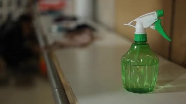 A man's hand takes a plastic pumping bottle sanitizer from the shelf. Bottle of alcohol sanitizer gel dispenser bottle.
