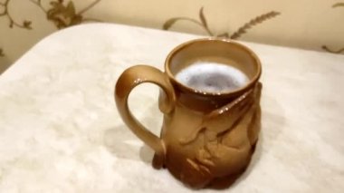 Adam masadan büyük bir kupa bira alıyor. Az alkollü bira..