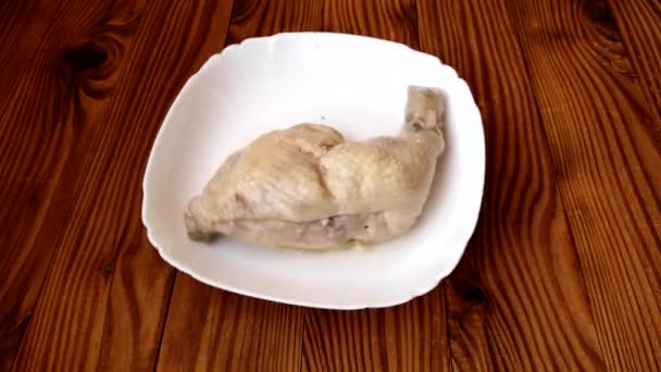 Gekochte Hähnchenkeule Rotiert Einem Weißen Teller Auf Einem Hölzernen Hintergrund — Stockvideo