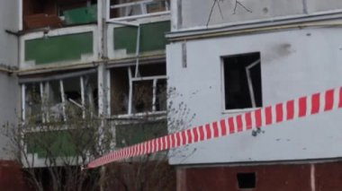 Rus uçakları Ukrayna şehrini bombaladıktan sonra yıkılan bir yerleşim yerinin yakınındaki kırmızı-beyaz sinyal bandının kapatılması. Rusya 'nın Ukrayna' ya karşı savaşı.