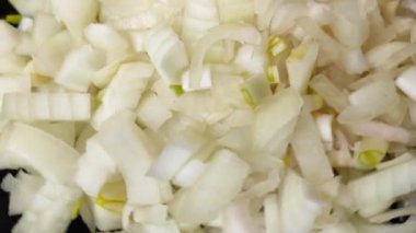 Yakından bakınca dilimlenmiş soğan siyah bir tabakta döner..