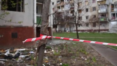 Enclosing red-white signal tape area near a destroyed residential building after the bombing of the Ukrainian city by Russian aircraft. Ruins of city Chernihiv of terrorist attacks, bomb shelling.