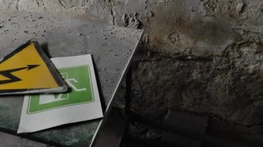 Yangın alarmına karşı elektrik tehlike işaretleri ve tahliye çıkış yönü. Yüksek voltaj işareti. Tabela, logo, amblem ya da terk edilmiş binadaki tesislerin yangın güvenliği sembolü..