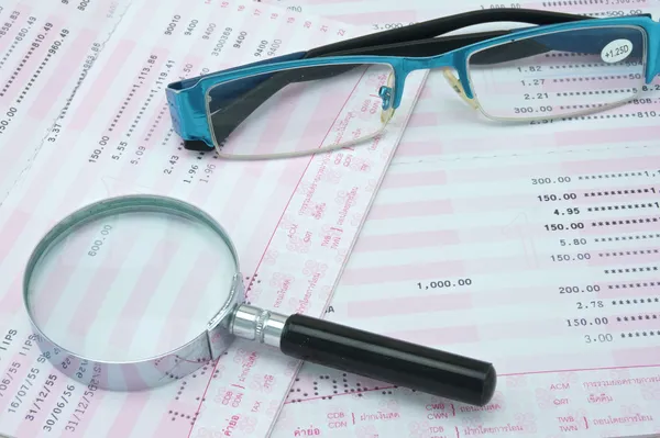 Magnifier and spectacles on bank account — Stock Photo, Image