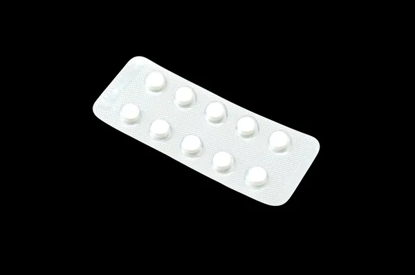 White tablets isolated on black background — Stock Photo, Image