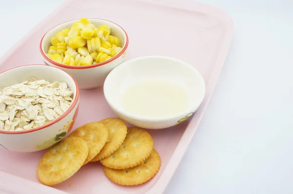トウモロコシ、オートムギ、クラッカー、ピンクのトレイ上の甘くされたコンデンス ミルク — ストック写真