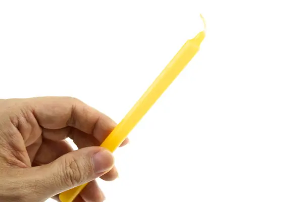 Mão segurar vela amarela para iluminado a partir de fundo esquerdo isolado — Fotografia de Stock