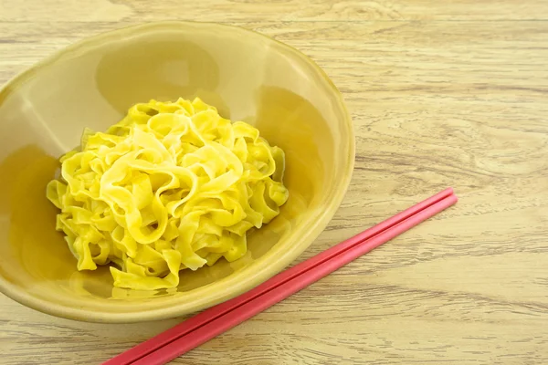 Grande macarrão amarelo escaldar em tigela marrom e pauzinhos — Fotografia de Stock