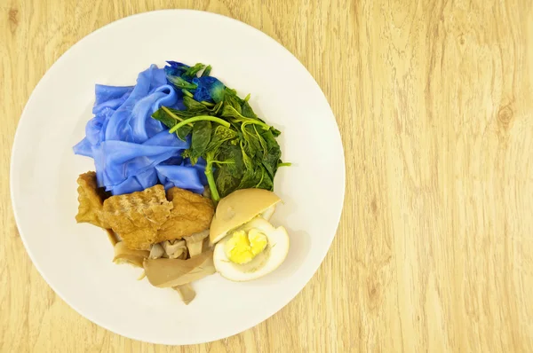 Fideos de arroz azul salsa fondo de madera vegetariana — Foto de Stock