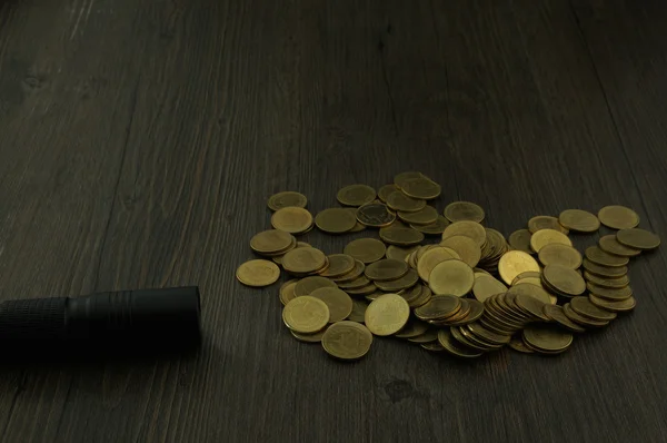 Open flashlight to find hair on pile of gold coins — Stock Photo, Image