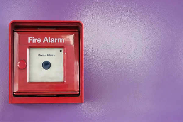 Röda rutan för brandlarm på violett vägg — Stockfoto