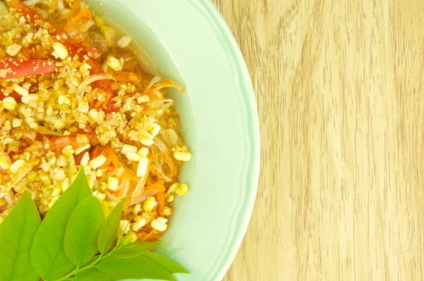 Green papaya salad or som tam with leaves of gooseberry — Stock Photo, Image