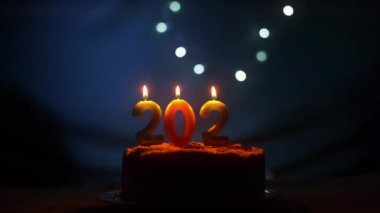 Yeni yıl 2022 'yi parti pastasına el yapımı ve yanan mumla dolduruyorum.