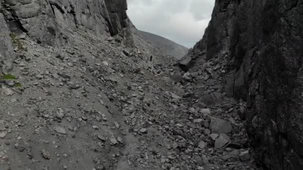 Luftaufnahme einer tiefen Schlucht zwischen Bergen, die mit grauen Steinen übersät sind — Stockvideo